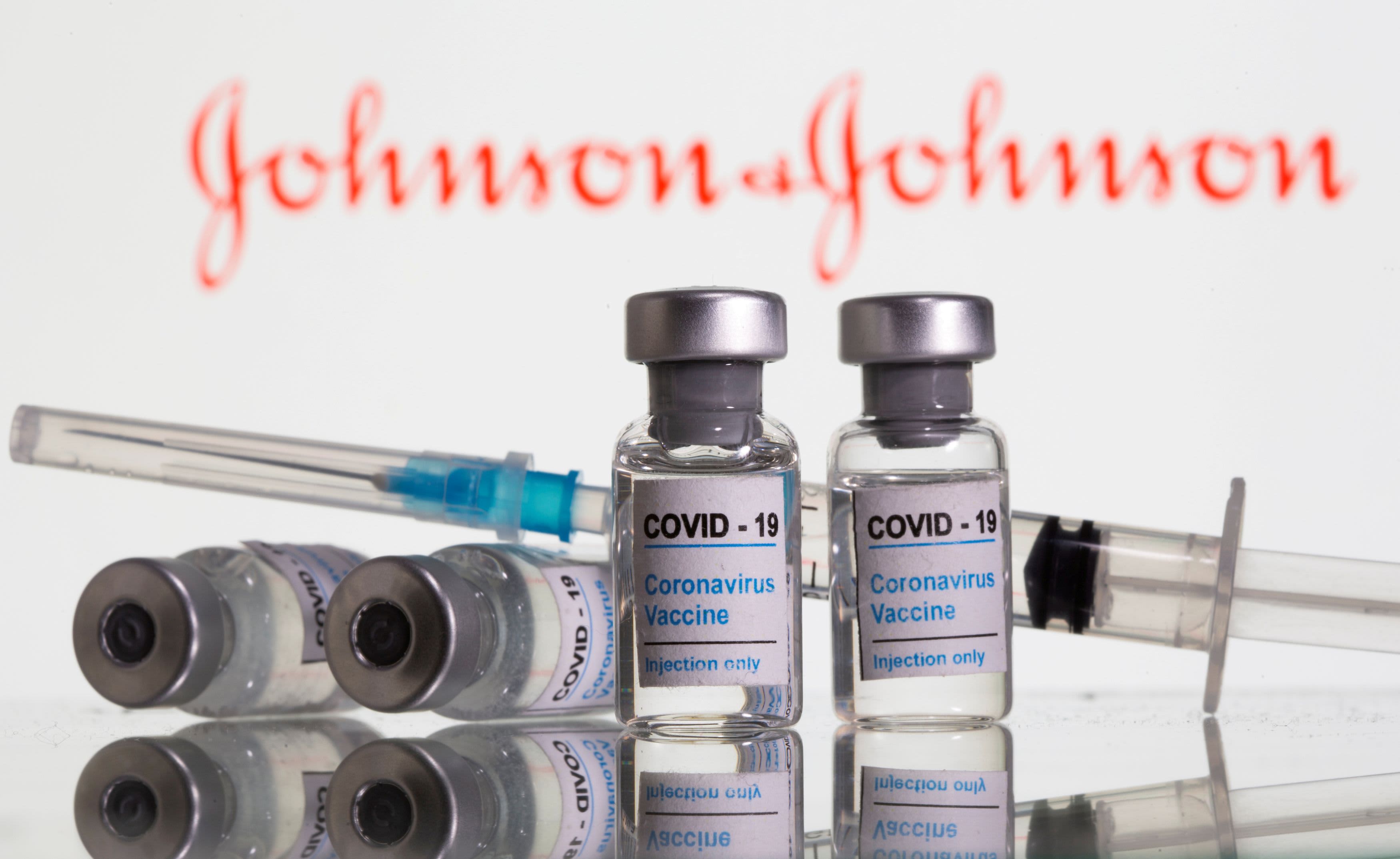 Vials labelled "COVID-19 Coronavirus Vaccine" and syringe are seen in front of displayed Johnson & Johnson logo in this illustration taken, February 9, 2021.