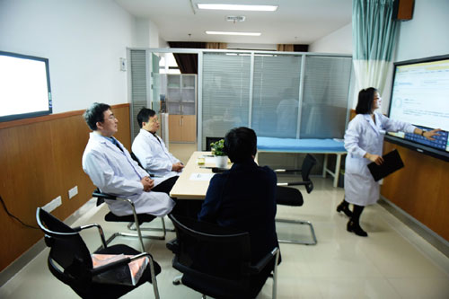 1月17日，在微医集团杭州手术中心的远程会诊室，医疗专家查看患者的病历。