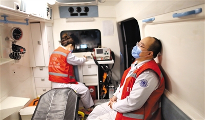 2月5日晚，医护人员在救护车内待命。
